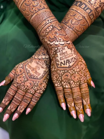 The back of the hands of a bride, featuring her and her groom's names. Personalizing the mehendi with names and dates is a beautiful way to add a special touch.