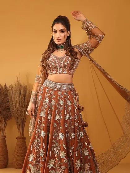 A full-length shot of the model in a beautiful embroidered lehenga, her look completed by our elegant emerald choker.