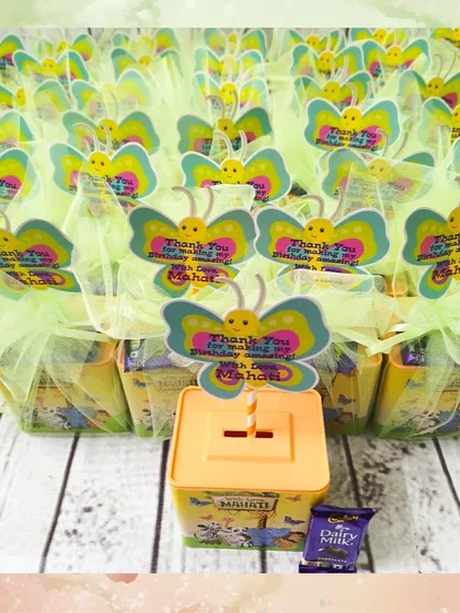 A full batch of the jungle-themed piggy banks, all wrapped and ready to be given out as party favors. The butterfly tags add a touch of whimsy.
