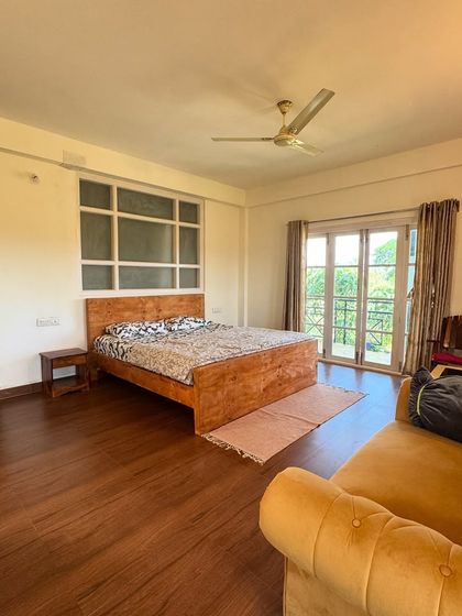 The spacious and airy bedroom at the farm stay, with a view of the fields outside.