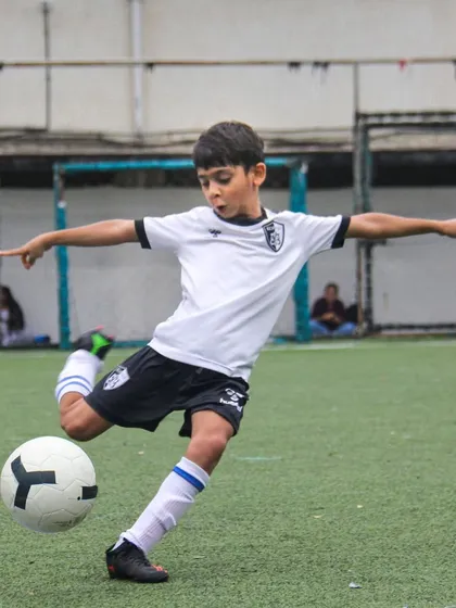 A player practices his shooting form, capturing the moment of impact and follow-through required for a powerful and accurate strike on goal.