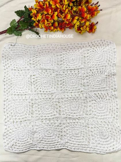 This square white table mat is made with a beautiful, textured pattern. It's a timeless piece that works well as a centerpiece on a coffee table or dining table.