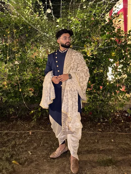 A client looking sharp in our navy blue Indo-Western set with a printed dushala. This is a great rental option for a sangeet or reception, offering a modern yet traditional vibe.
