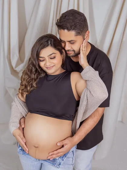 An intimate close-up, capturing the tenderness between the couple in their casual denim-themed maternity shoot.