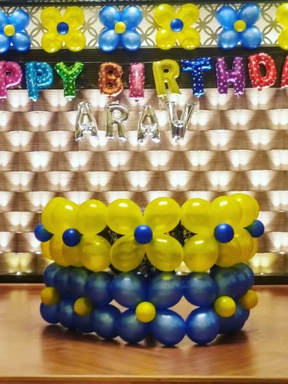 A custom cake table made of balloons for a Minions theme party. I also created a balloon flower border on the wall behind it.