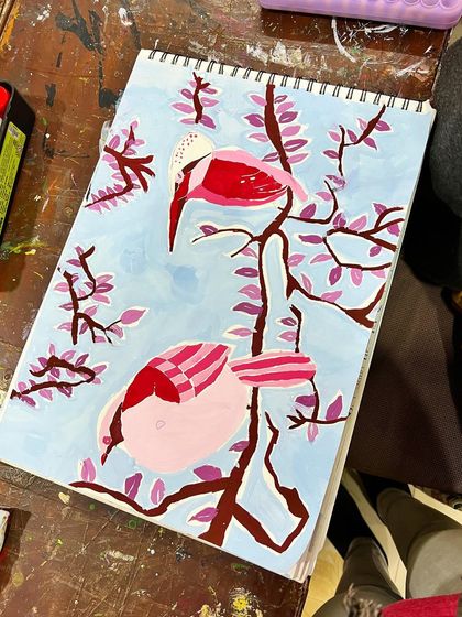 A lovely painting of two pink birds on a branch, showcasing a student's ability to create a serene scene with poster colors.