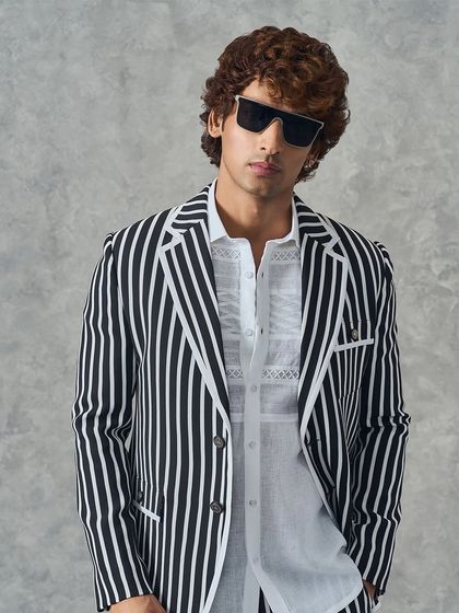 Another angle of the bold black and white striped suit. It's a powerful statement piece that combines the confidence of a suit with a playful, modern pattern.