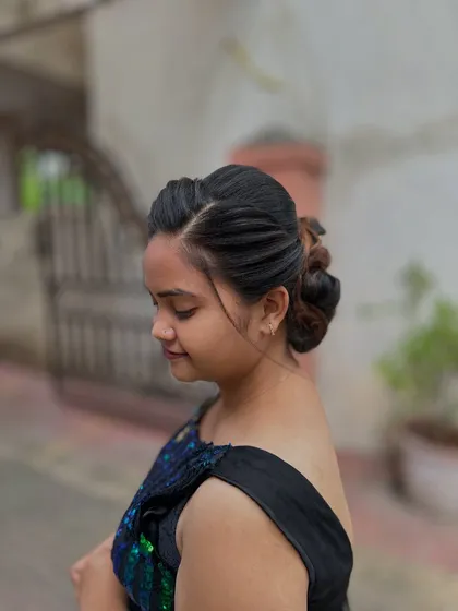 A side view of the low bun, showing the clean lines and smooth finish of the hairstyle.