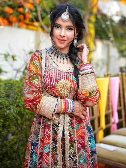 A full look at a multi-colored, intricately designed outfit for a Mehendi function. This demonstrates my experience with bridal and wedding-related photoshoots, complete with traditional jewelry and braided hair.