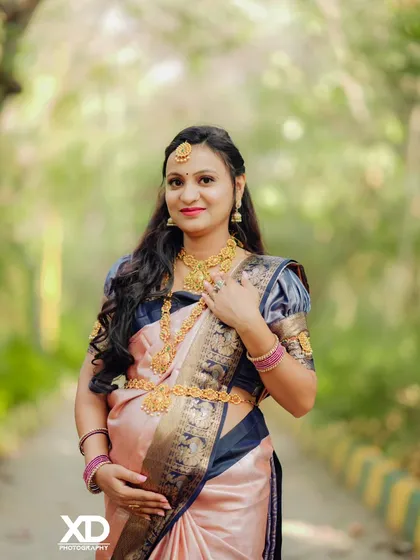 A lovely solo portrait of the mother-to-be in a beautiful silk saree, looking directly at the camera with a warm smile.