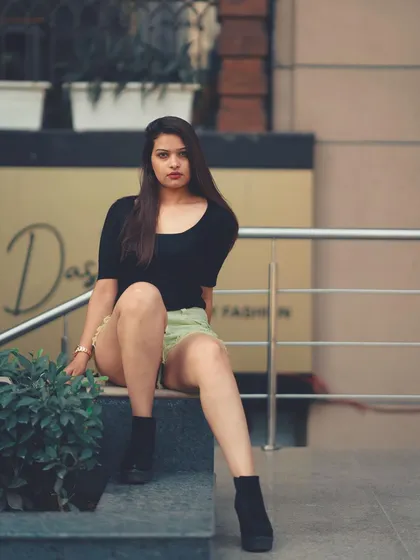 A full-body shot that showcases the entire outfit. The urban background adds a touch of grit that contrasts nicely with the fashion.