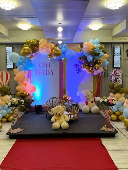 A front-facing view of the large 'Oh Baby' stage decoration, complete with a red carpet leading up to it.