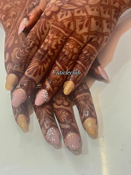 A delicate and pretty bridal look with soft pink and gold glitter nails. The accent nails feature tiny pearl embellishments for a sophisticated finish.