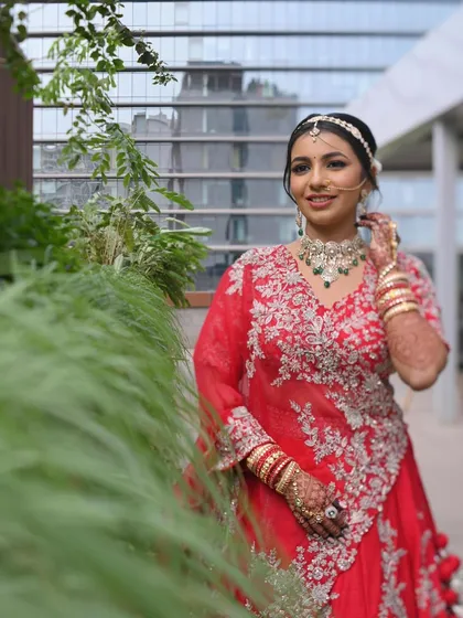 A lovely outdoor shot of the bride. The natural light enhances her glowing skin and the vibrant color of her red lehenga.