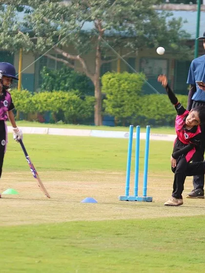 A young bowler from our U-10 program learning the basics of a run-up and delivery under the watchful eye of an umpire.