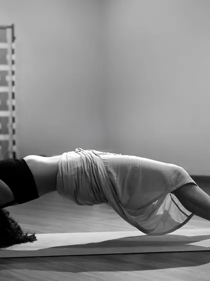 A black and white shot of my practice in a supported backbend, likely Dwi Pada Viparita Dandasana. This pose offers a deep opening for the chest and shoulders.