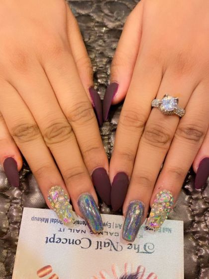 A duplicate of image 61, showing a dramatic combination of matte burgundy coffin nails with holographic chrome and multi-colored crystal accent nails.