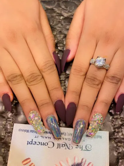 A duplicate of image 61, showing a dramatic combination of matte burgundy coffin nails with holographic chrome and multi-colored crystal accent nails.