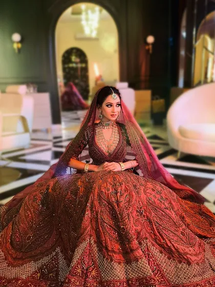 A wide shot showing the grandeur of the bridal lehenga and the palatial setting. The makeup completes this picture of a modern-day maharani.