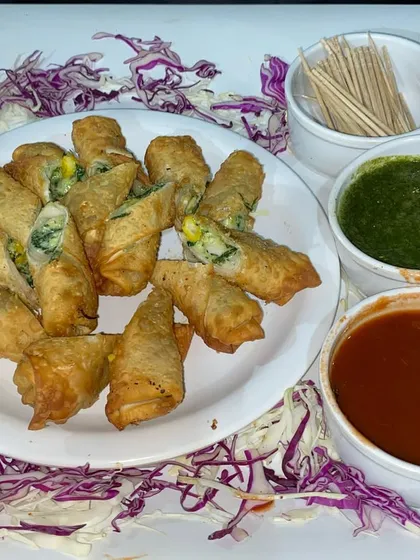 Crispy cheese corn rolls served with green chutney and sweet tamarind sauce, a perfect bite-sized appetizer.