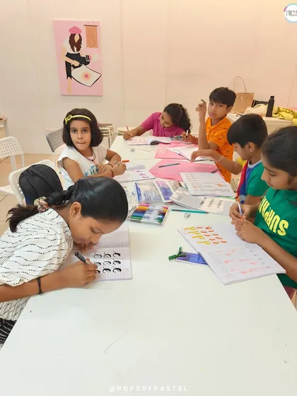 Little hands learning the art of brush lettering. Our workshops for kids are designed to be fun, engaging, and educational.