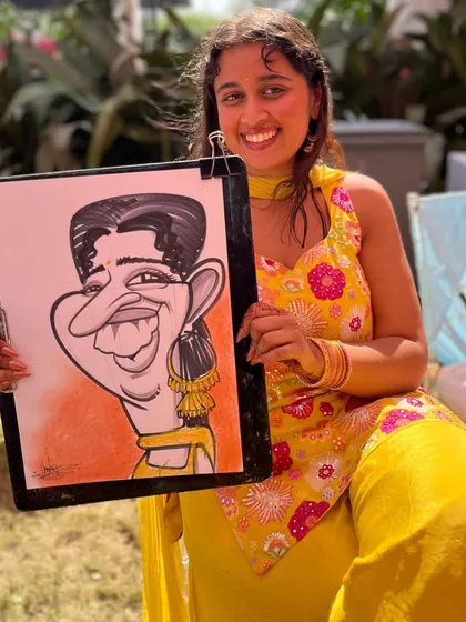 Another happy guest at the Lonavala wedding, holding her fun portrait. The sunny outdoor setting made for a wonderful day of drawing.