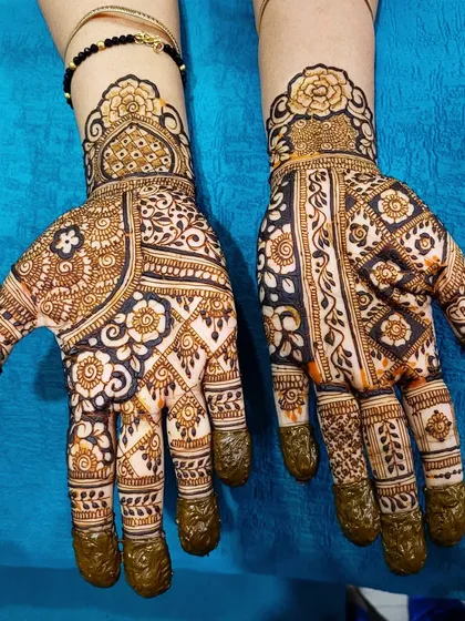 A beautiful and intricate design perfect for a bride or for festivals like Teej. The mix of bold, dark elements and delicate, fine lines creates a lot of depth.