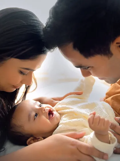 A classic family pose, looking down with love at their beautiful baby. This image from a 6-month session is a perfect snapshot of a family's world revolving around their little one.