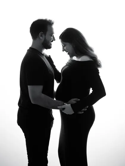 Sometimes, a simple silhouette in black and white can tell the most powerful story. This image captures the shared joy and anticipation between two people about to become parents, a timeless memory of their connection.