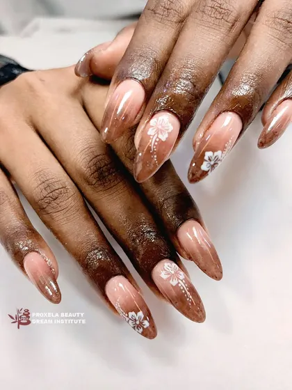 An elegant and earthy design. I painted delicate white flowers on a brown gradient base, creating a beautiful contrast on these long almond-shaped extensions.
