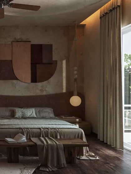 This rustic retreat is grounded in the warmth of a deep rust undertone. The bed is set against a textured wall with a custom art piece, and a single pendant light adds a soft, ambient glow.