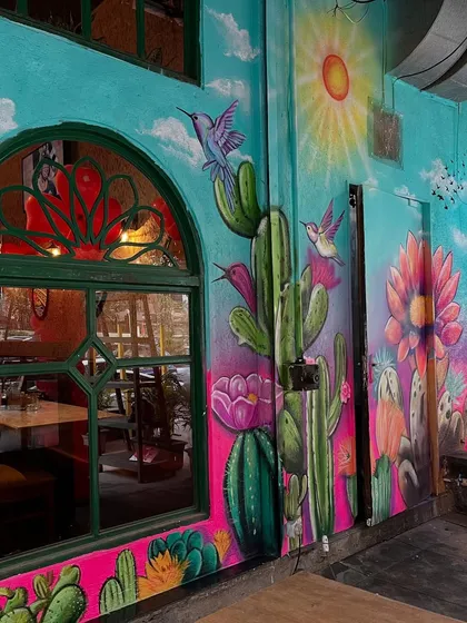 Another view of the colorful Mexican-themed mural, showcasing the lively composition of birds, cacti, and flowers.