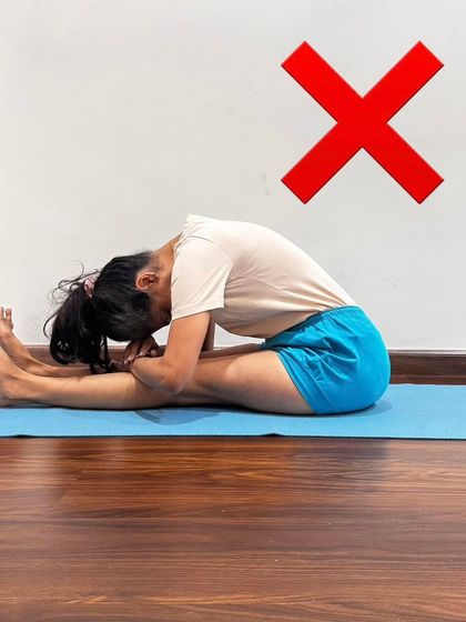 An example of an incorrect Paschimottanasana (Seated Forward Bend) with a rounded spine. My method focuses on correcting such patterns to avoid strain and achieve the true benefits of the pose.