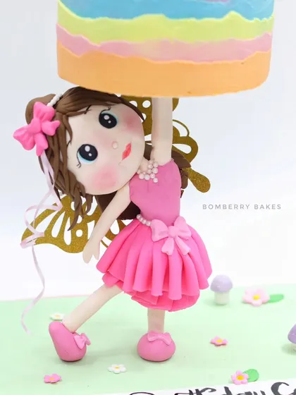 A close-up of the hand-sculpted fondant girl figurine, the central element of my gravity-defying cake. Her pose and expression are key to the cake's story.