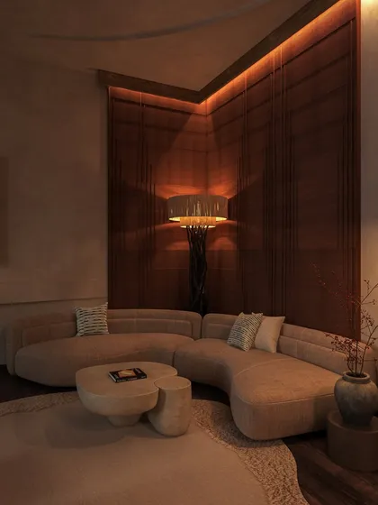 A cozy seating area with a curved sofa is set against a dark, wood-paneled corner. A sculptural floor lamp casts a warm, intimate light, making it a perfect spot to unwind.