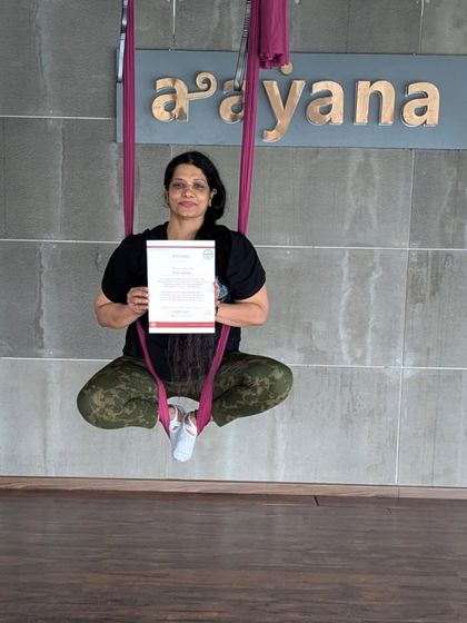 Seated peacefully in the hammock, this student holds her certificate after completing the intensive training.