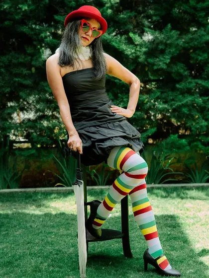 We had so much fun creating this whimsical look inspired by Alice in Wonderland and the Mad Hatter. The colorful striped stockings and red accessories bring the fantasy to life.