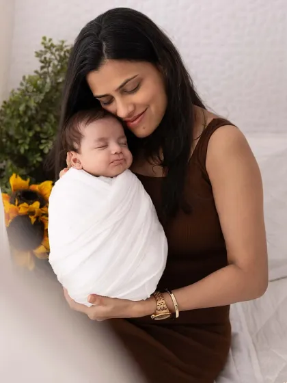 There is nothing more powerful than a mother's love. In this tender moment, a new mom holds her peacefully sleeping newborn, wrapped snugly and safely. These are the quiet, emotional connections I aim to freeze in time during a newborn family session.