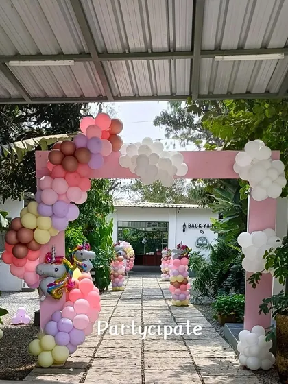 A full view of the magical entrance walkway, lined with unicorn balloon pillars, leading to the main party area.