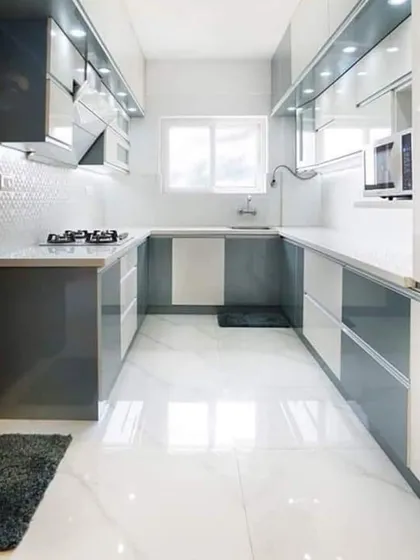 Here is a finished U-shaped modular kitchen, designed for maximum efficiency. The white and grey handleless cabinets create a clean, modern look, while under-cabinet lighting ensures the workspace is always well-lit.