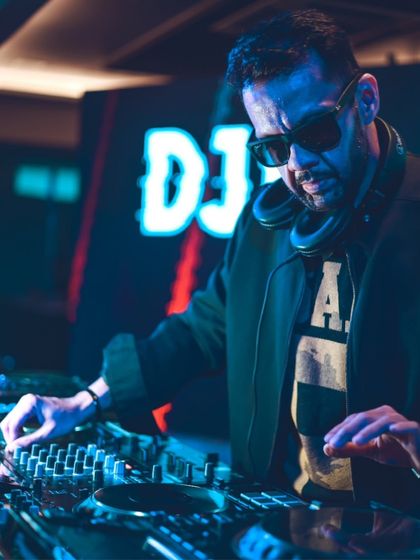 DJing in front of a neon sign with my logo. A custom visual setup like this adds a professional touch to any corporate event or private party.