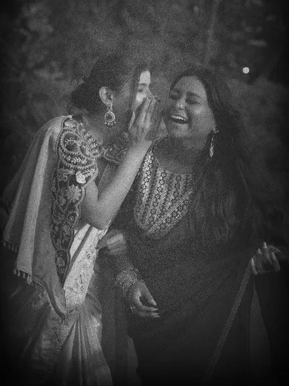 Two friends sharing a secret, captured in a classic black and white style. This shot tells a story and evokes a sense of nostalgia and timeless friendship.