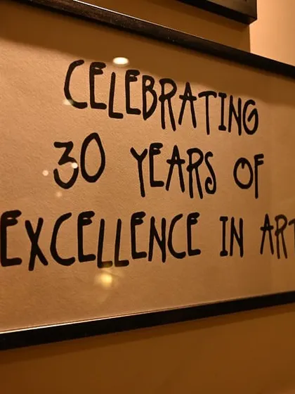 For over 30 years, I have been dedicated to fostering a love for art. This sign from our anniversary exhibition represents three decades of creativity, community, and countless masterpieces made within these walls.