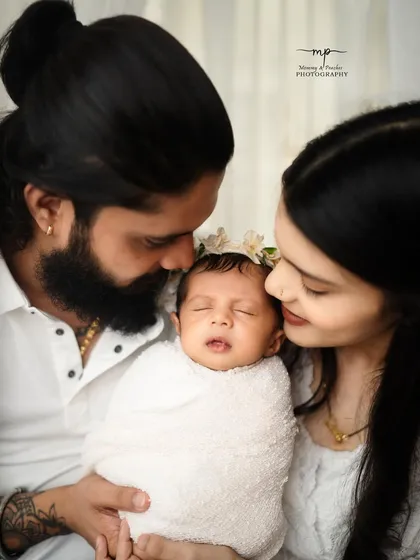 A beautiful close-up of new parents admiring their sleeping baby. The image is full of tenderness, highlighting the delicate features of the newborn and the parents' adoration.
