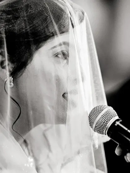 A close-up of the bride saying her vows, seen through her veil. This intimate shot focuses on the intensity and emotion of the promises being made.