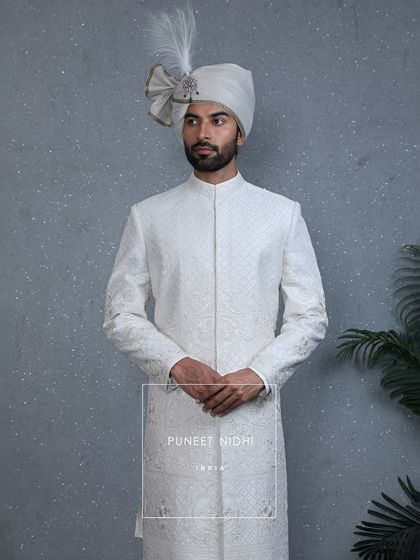 A view of the ivory sherwani without the stole, showcasing the clean lines and the detailed embroidery and beadwork that come alive with emotion.