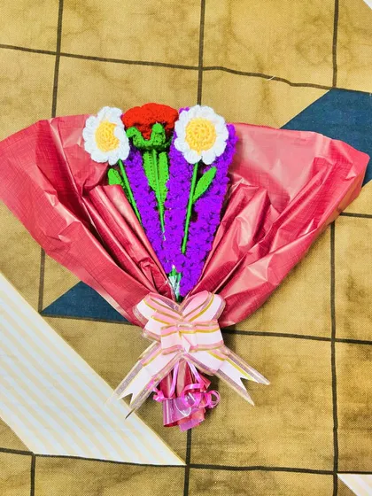 A cheerful bouquet featuring crochet daisies and lavender, wrapped in bright pink paper. This arrangement is perfect for birthdays or just to brighten someone's day.