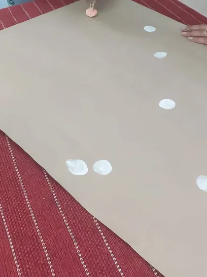 The first step in our DIY wrapping paper activity. Using simple materials like craft paper and paint, we show children how to create beautiful patterns for the holiday season.