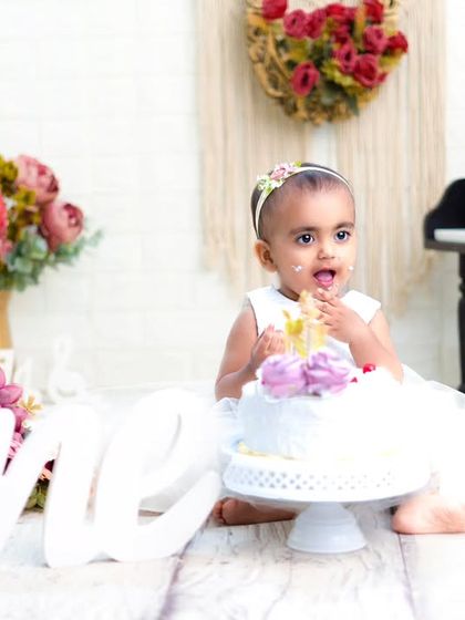 A sweet and simple cake smash moment. This little girl is enjoying her first taste of birthday cake in a lovely, rustic-themed setup.