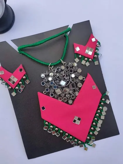 I love working with bright colours, and this pink and green fabric necklace set is a perfect example. It features a large mirror work pendant and matching earrings with ghungroos, making it a true statement piece for any celebration.
